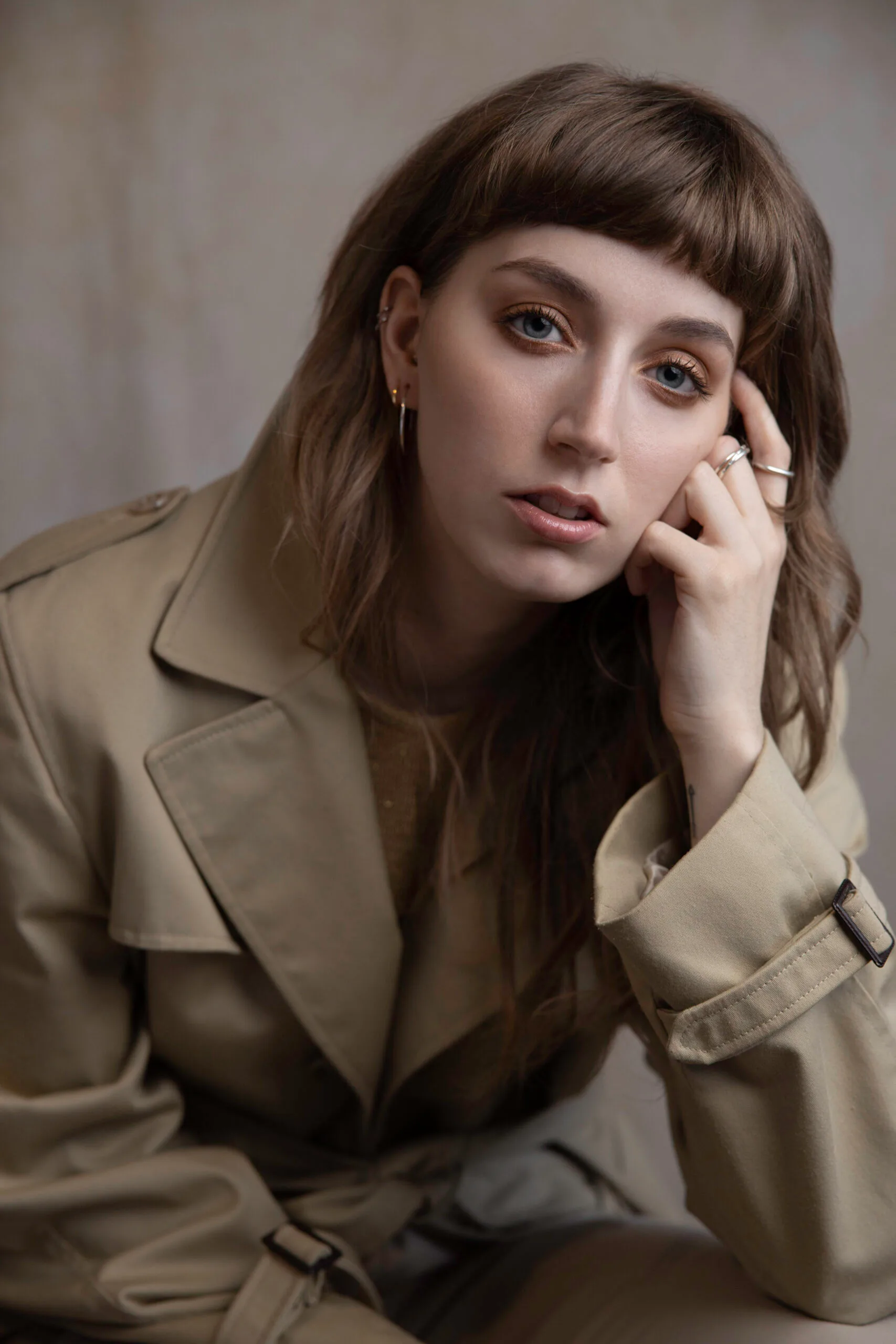 Photographe portrait studio – femme en trench beige regard intense