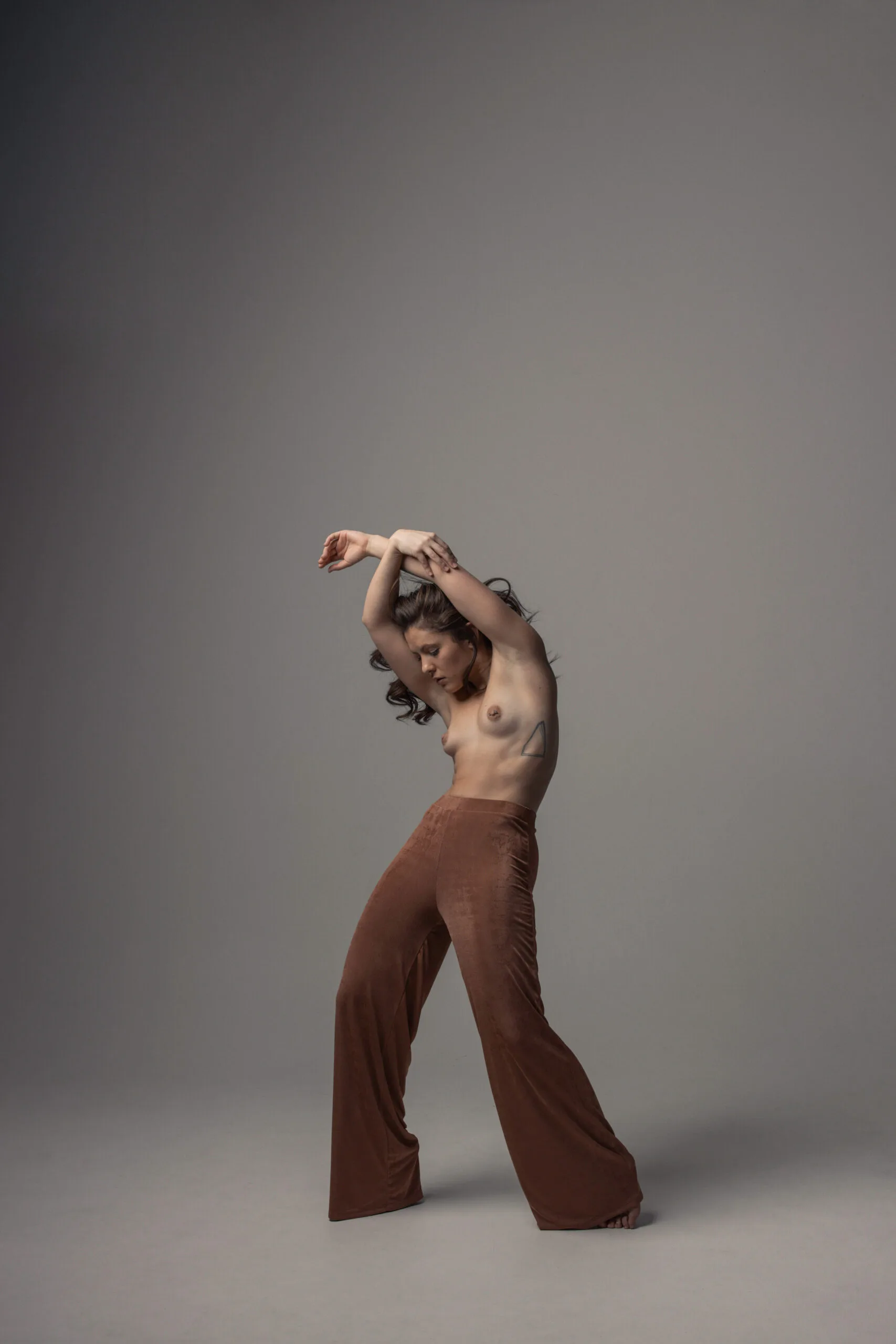 Photographie nu artistique – pose féminine dramatique en lumière oblique