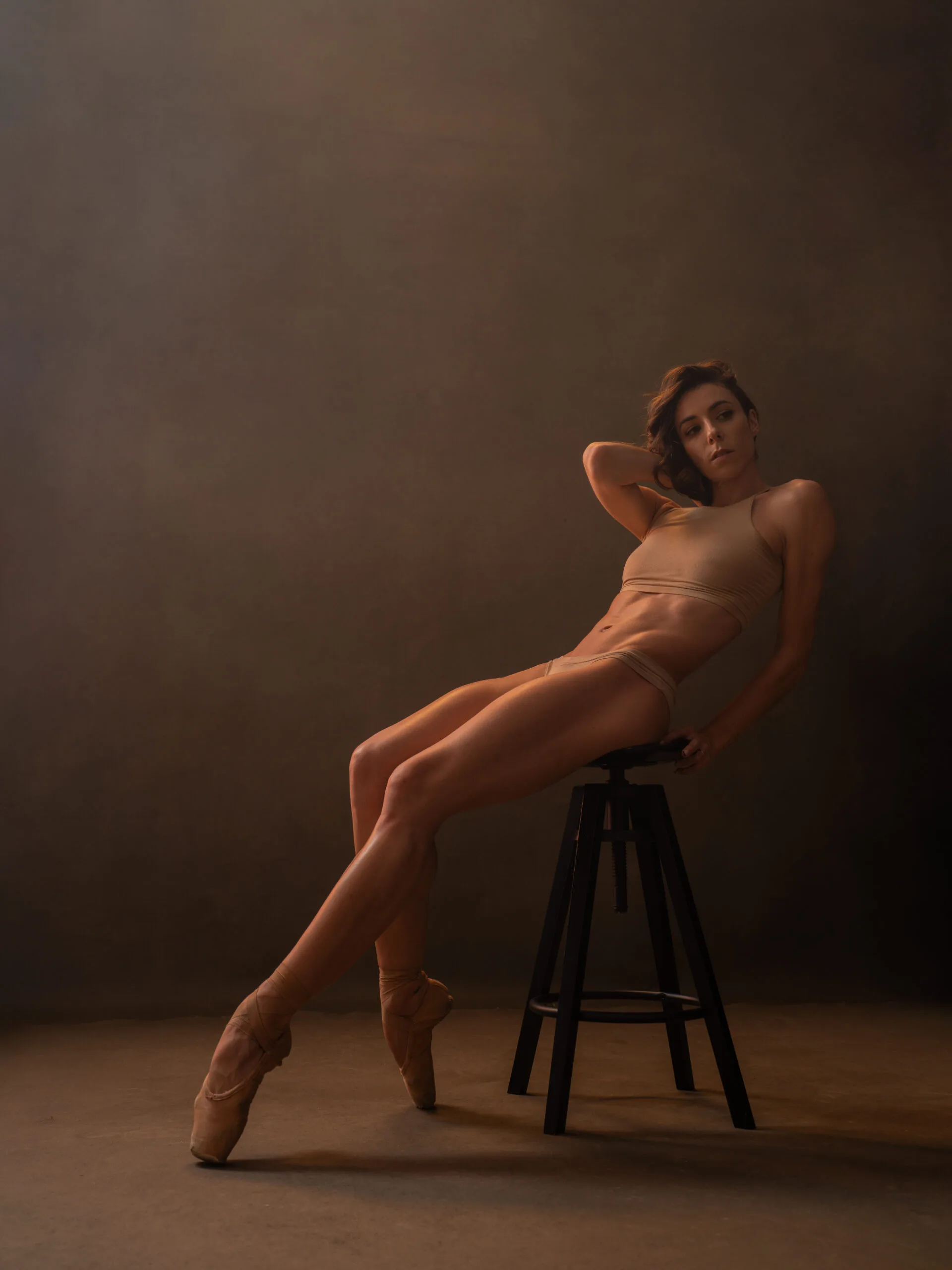 Photographe portrait artistique – pose assise dramatique en lumière studio