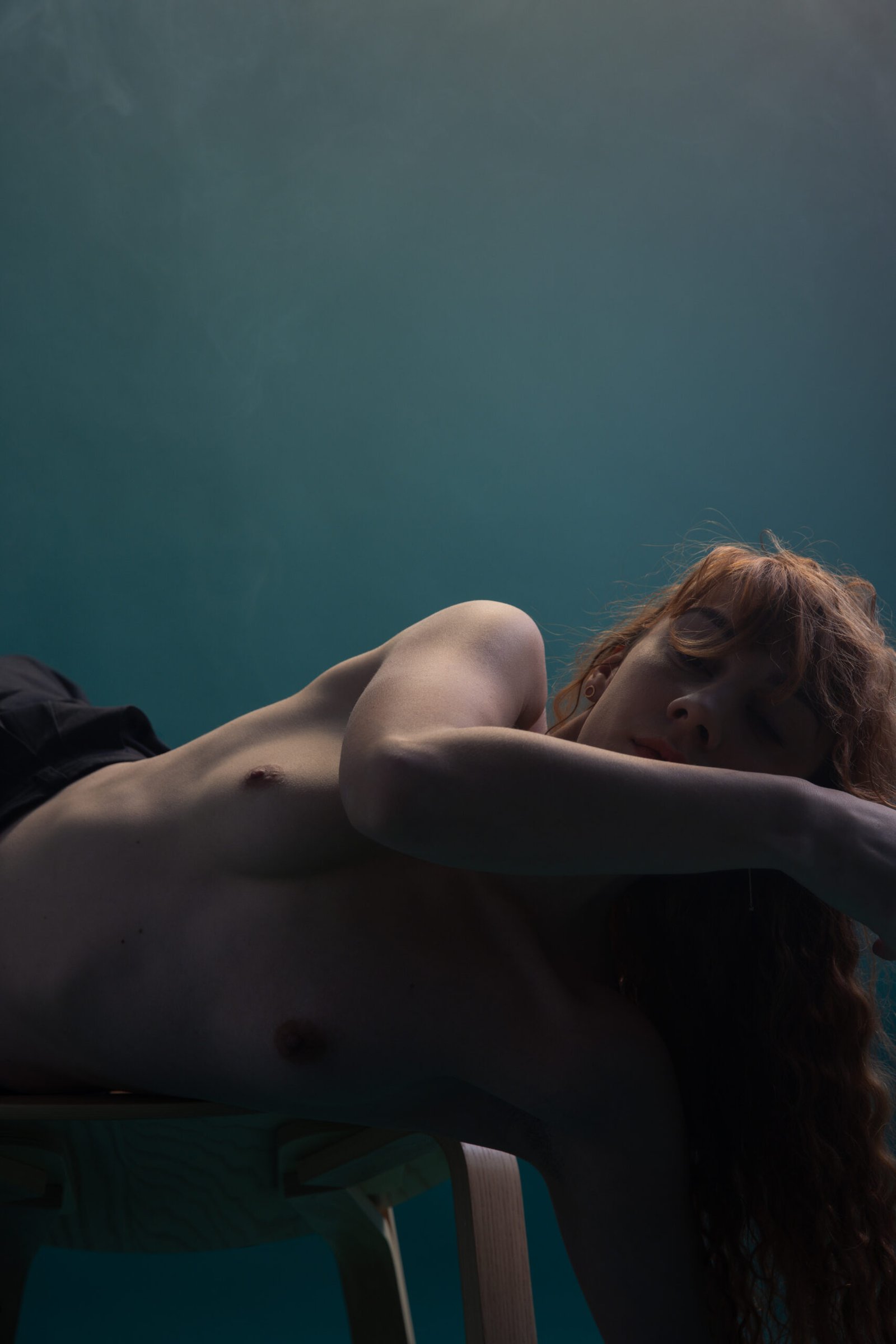 Photographe boudoir artistique – femme allongée en lumière tamisée à Montréal