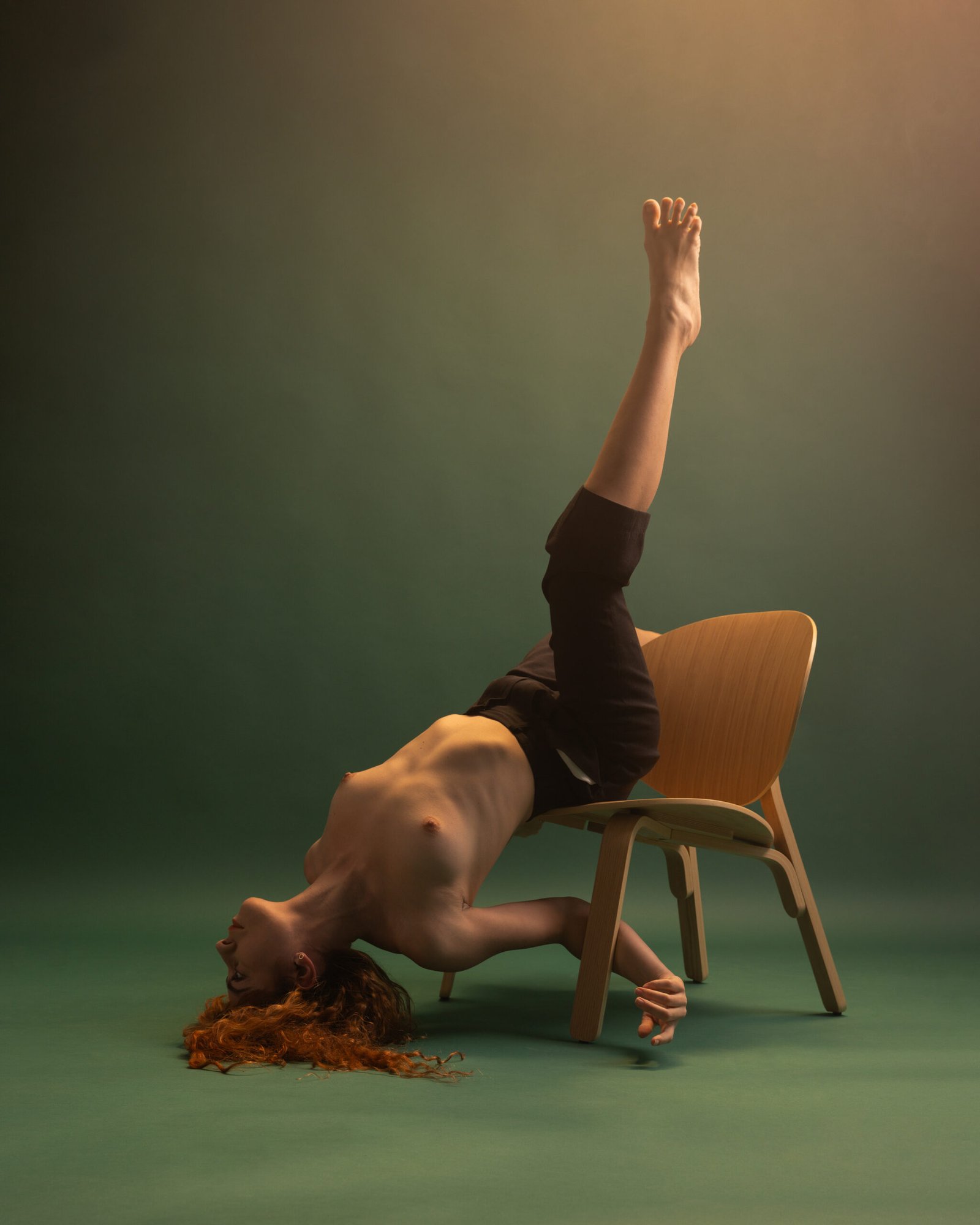 Photographe artistique studio – pose inversée dynamique sur chaise